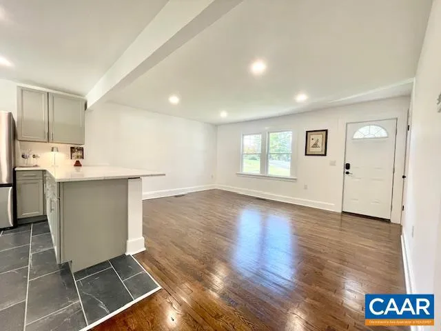 a view of a kitchen with fridge and wooden floor