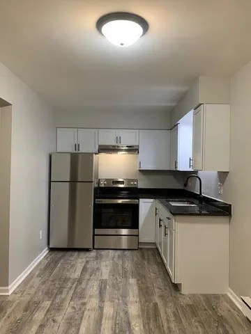 a kitchen with stainless steel appliances granite countertop a stove a refrigerator and a sink