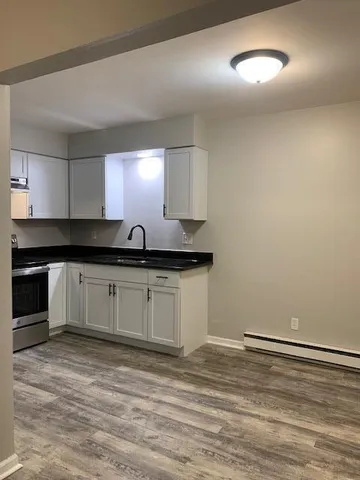 a kitchen with a sink cabinets and a wooden floor