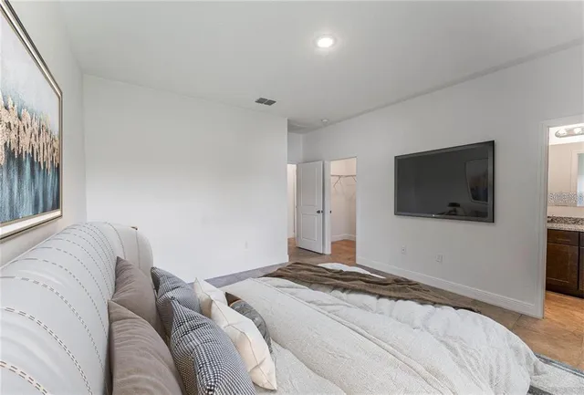 a bedroom with a bed and a flat screen tv