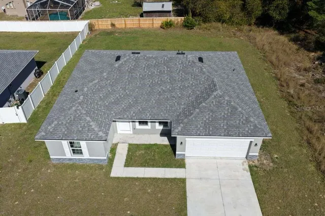 an aerial view of a house with backyard