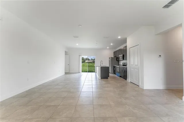 a view of a kitchen with a sink and an empty room