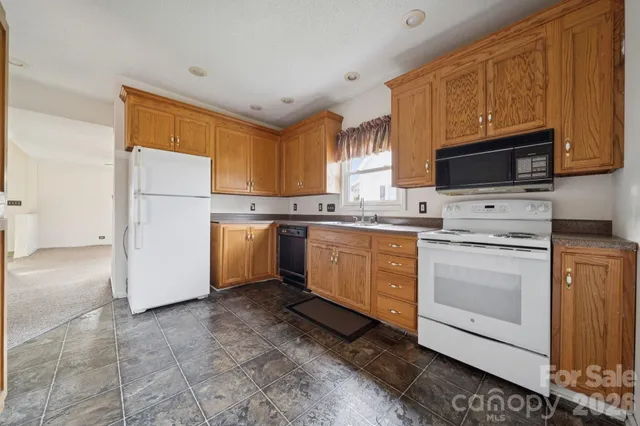 a kitchen with a white stove top oven and white stainless steel appliances