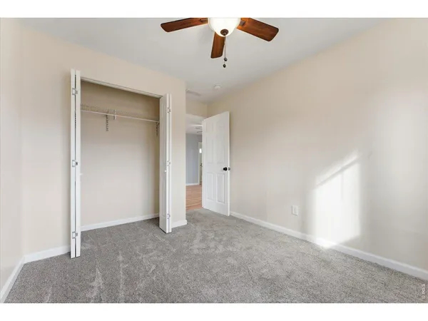 en empty room with ceiling fan and window