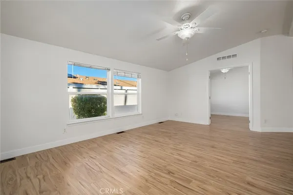 a view of an empty room with wooden floor