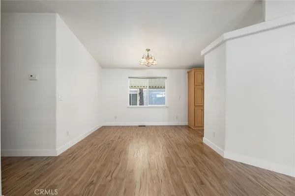a view of a kitchen with wooden floor and electronic appliances