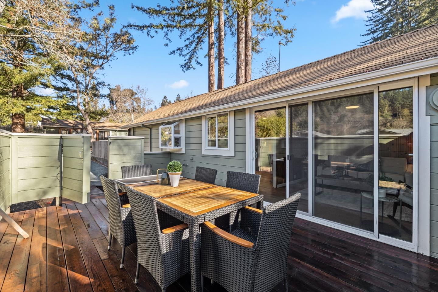 a view of a patio with table and chairs with wooden floor and fence