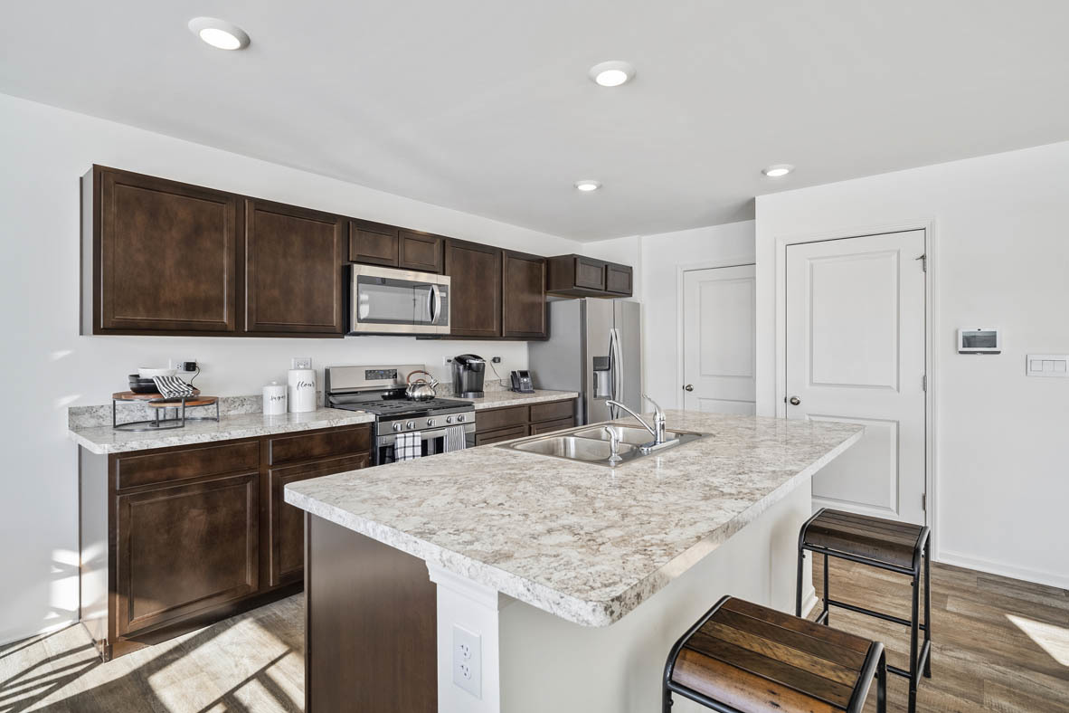 10 International Way Joliet, IL 60421 - Photo 15 of 32 a kitchen with stainless steel appliances granite countertop a stove top oven a sink refrigerator and cabinets