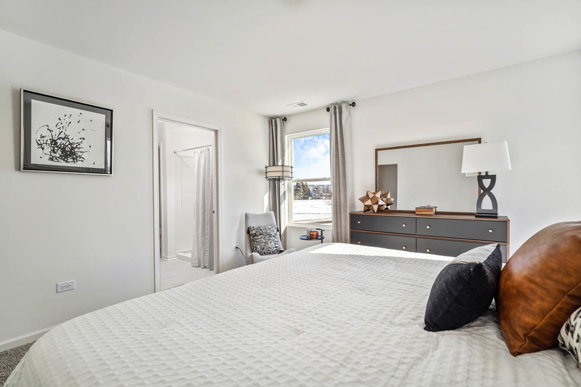 10 International Way Joliet, IL 60421 - Photo 26 of 32 a bedroom with a bed and a large mirror