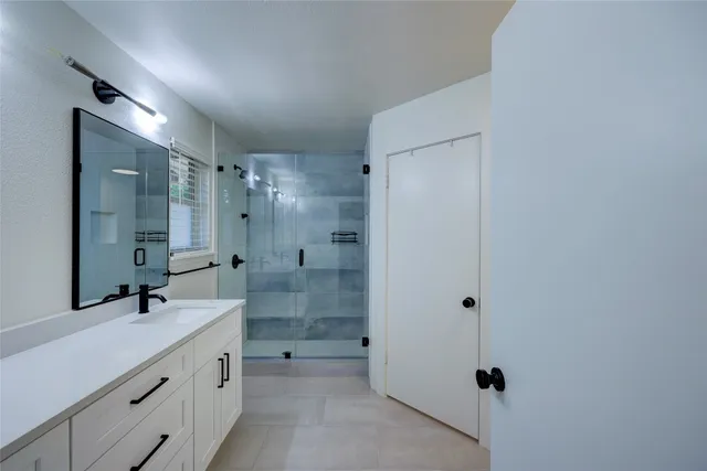 a bathroom with a double vanity sink a toilet and shower