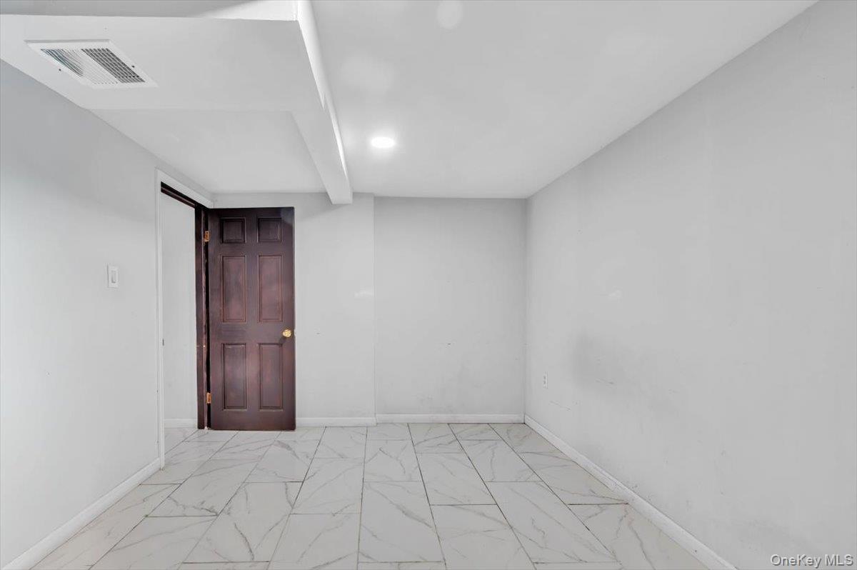 95-68 115th Street Queens, NY 11419 - Photo 21 of 28 Empty room with marble look tile flooring and baseboards