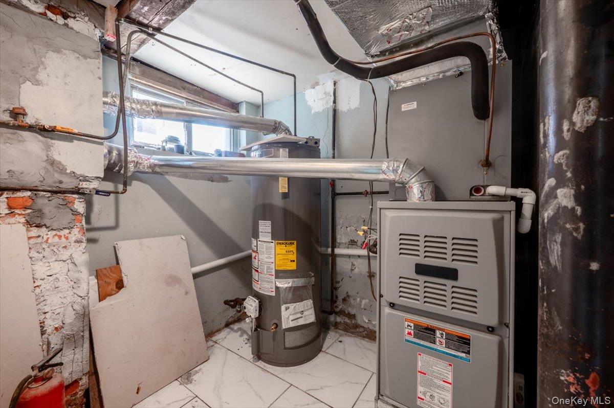 95-68 115th Street Queens, NY 11419 - Photo 22 of 28 Utility room featuring water heater