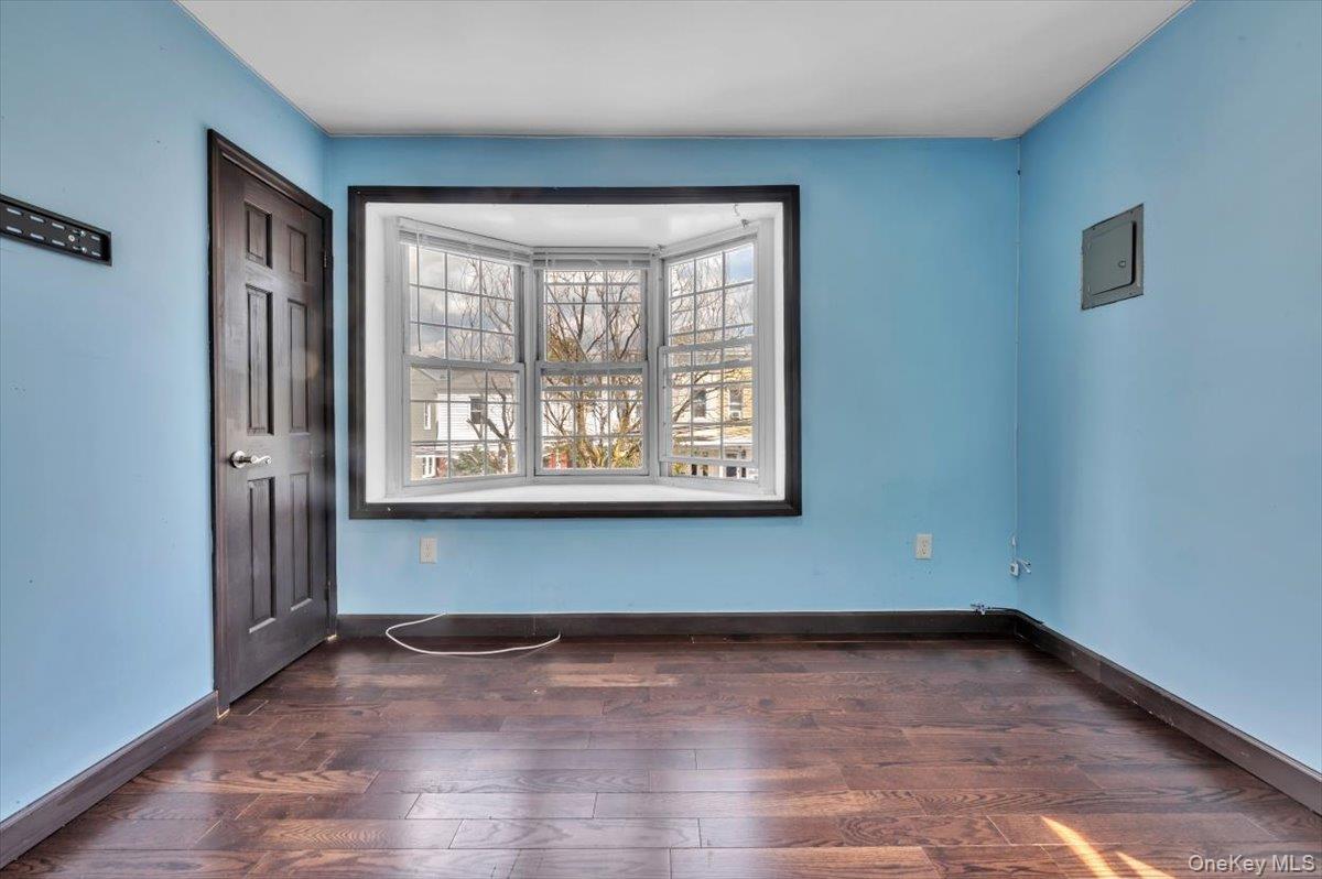 95-68 115th Street Queens, NY 11419 - Photo 6 of 28 Empty room featuring dark wood finished floors and electric panel