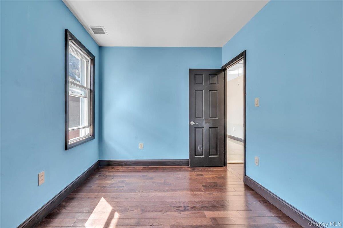 95-68 115th Street Queens, NY 11419 - Photo 7 of 28 Unfurnished bedroom featuring baseboards and dark wood-style floors