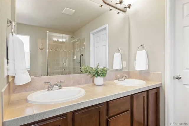 a bathroom with double vanity sinks and a mirror