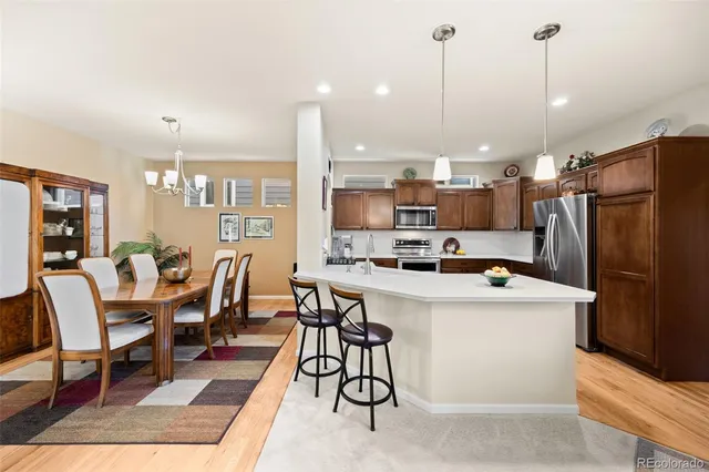 a kitchen that has a lot of cabinets a sink a dining table and chairs