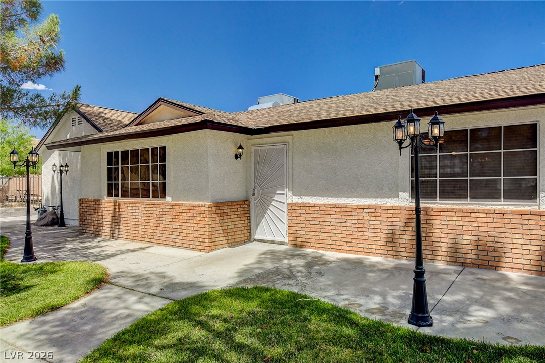 1810 Pinto Road Henderson, NV 89002 - Photo 6 of 53 A classic exterior boasts brick detailing, a secure entryway, and decorative lampposts.