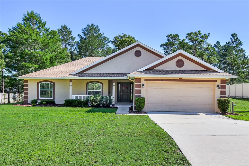 11213 Flock Avenue Weeki Wachee, FL 34613 - Photo 1 of 46 a front view of a house with a yard and garage