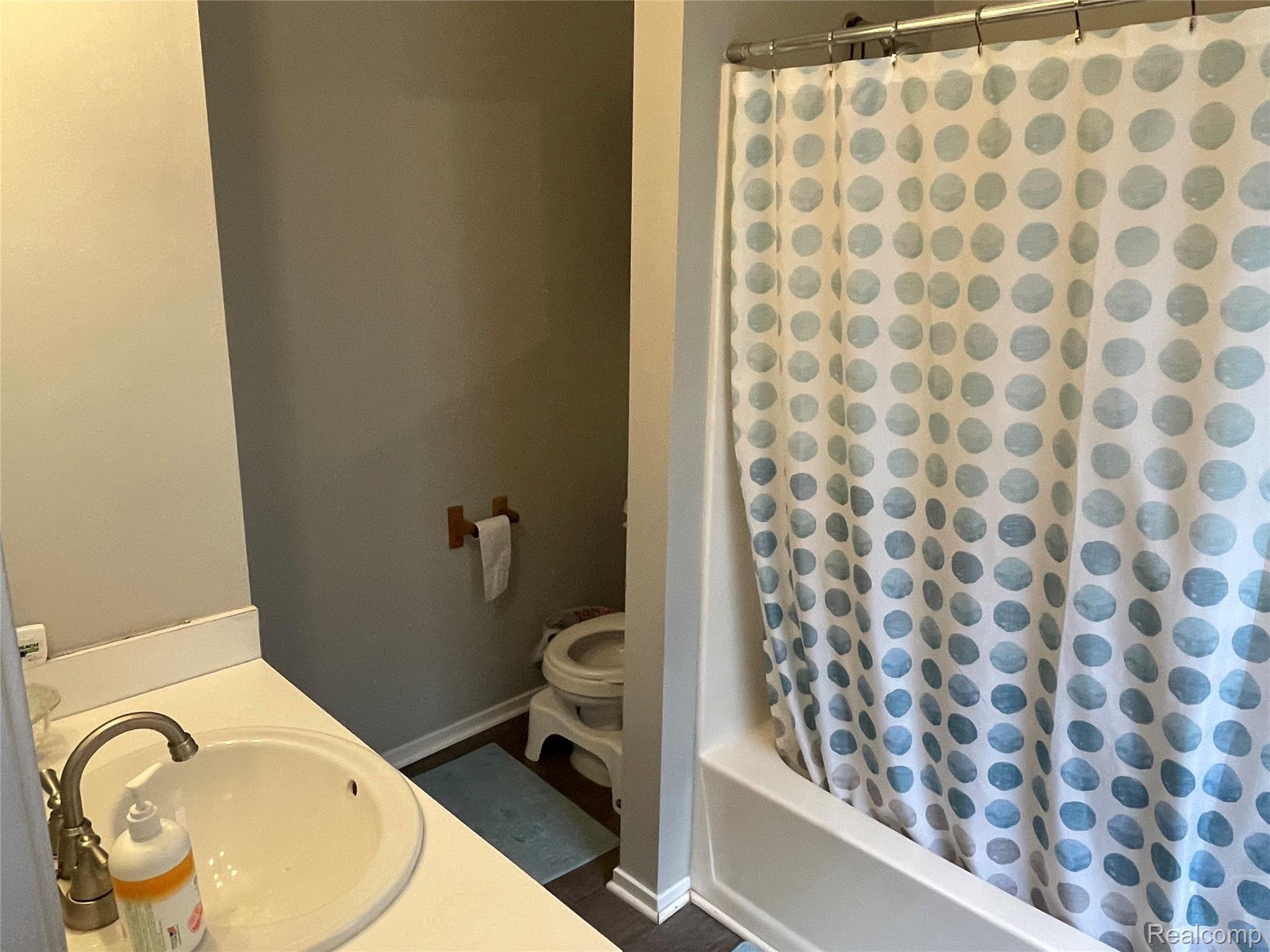 265 Reno Street Lake Orion, MI 48362 - Photo 6 of 11 Bathroom featuring a white bathtub, shower curtain rod, and a white vanity with an integrated sink and brushed nickel faucet