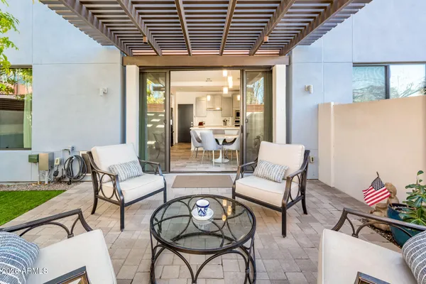 a view of a backyard with table and chairs potted plants and a palm tree