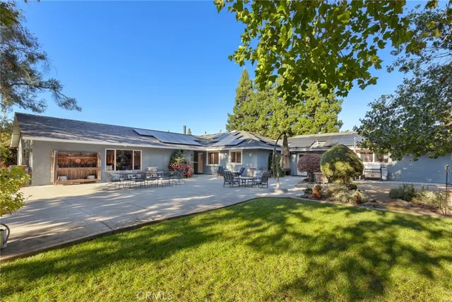 a view of a house with a yard patio and fire pit
