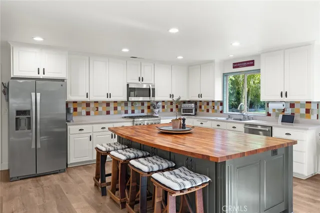 a kitchen with a table chairs a sink dishwasher refrigerator and stove