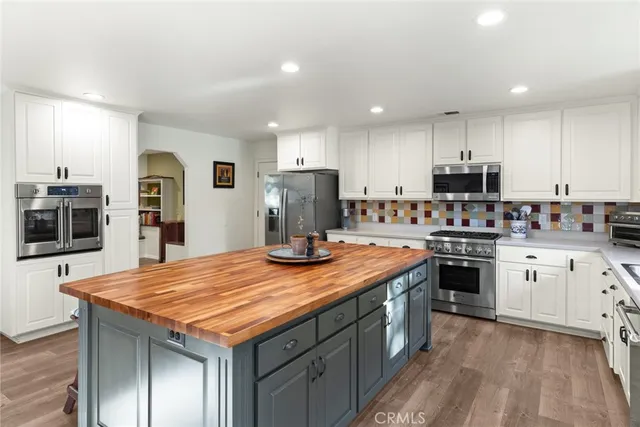 a kitchen with kitchen island granite countertop a stove and a sink