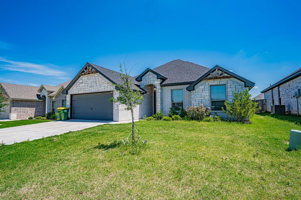 3315 Windcrest Drive Granbury, TX 76049 - Photo 1 of 1 a front view of a house with a yard and garage