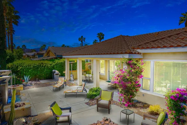 a view of a patio with a table and chairs under an umbrella