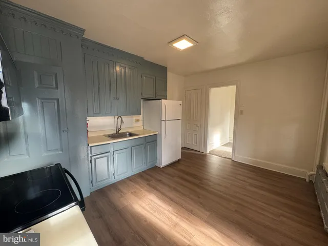 a kitchen with granite countertop a stove a sink and a refrigerator