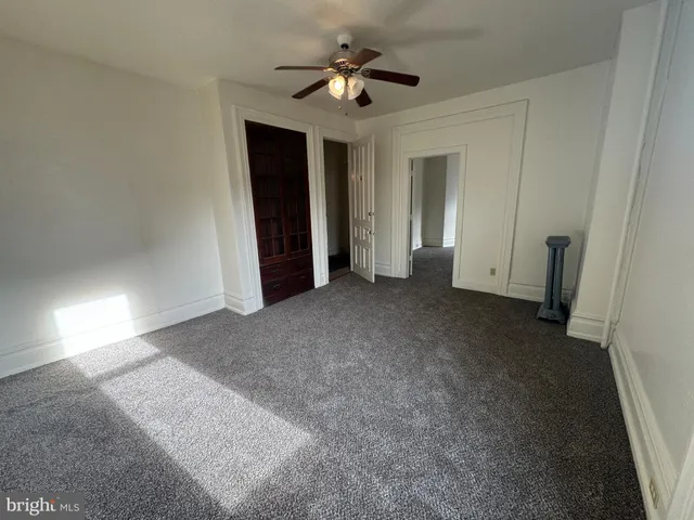 a view of a big room with closet and a ceiling fan