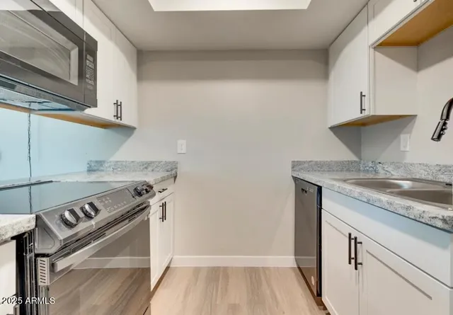 a kitchen with a stove and a wooden floor