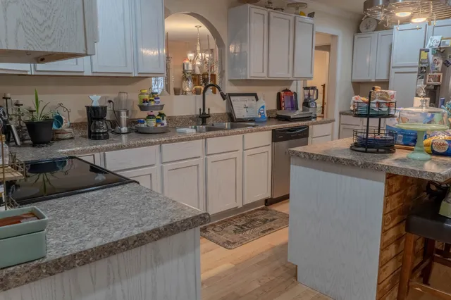 a kitchen with stainless steel appliances granite countertop a sink stove and cabinets