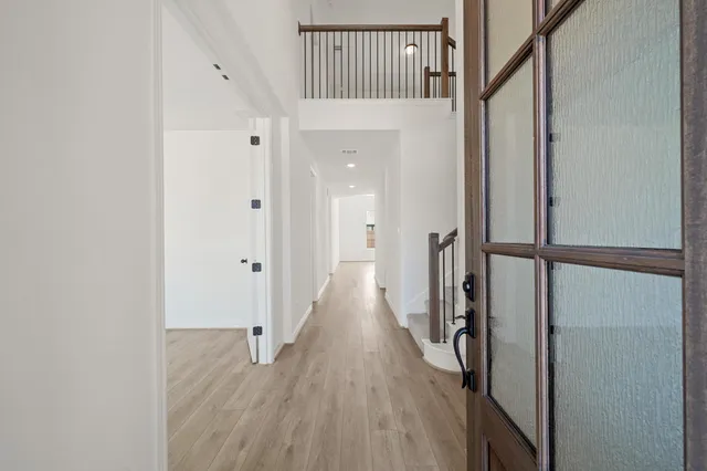 a view of hallway with wooden floor and stairs