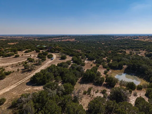 an aerial view of house with yard and mountain view in back