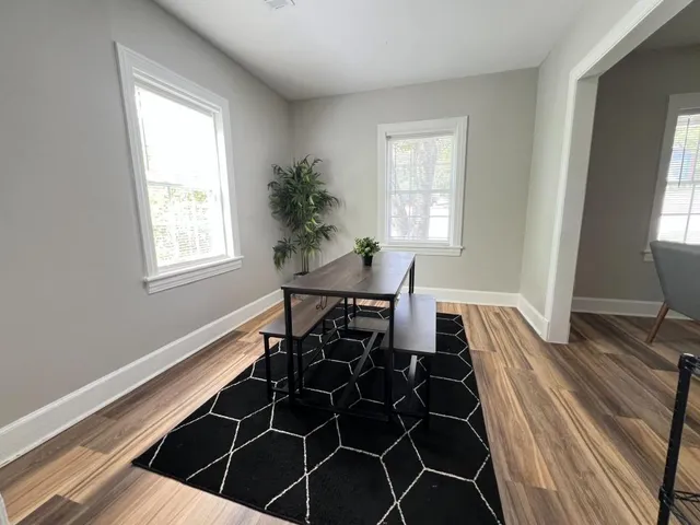 a living room with a table chair and a window