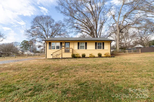 a front view of house with yard and trees around