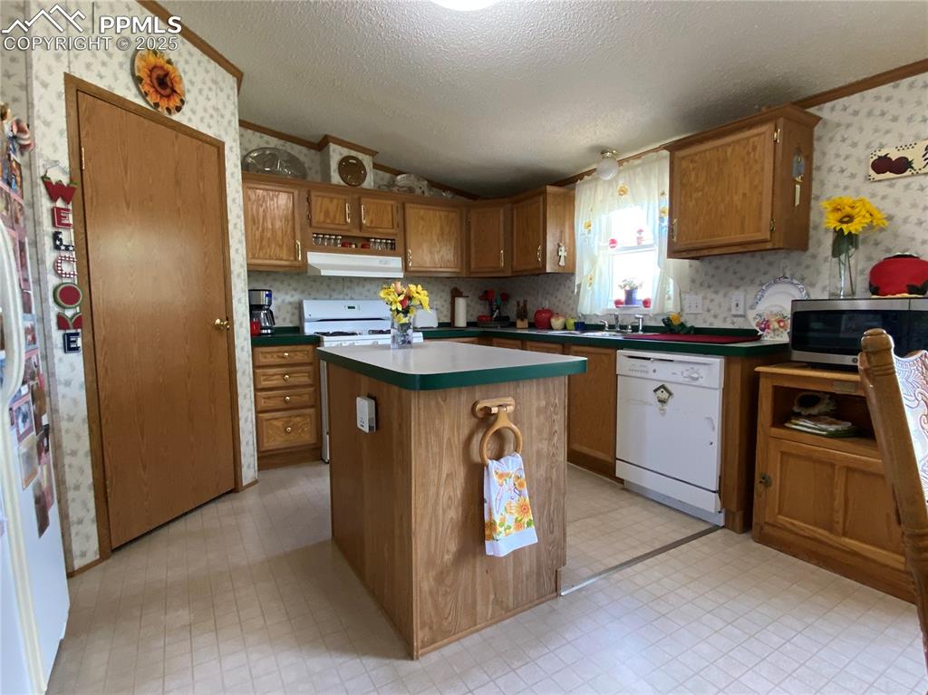 3955 South Meridian Road Colorado Springs, CO 80929 - Photo 9 of 39 a kitchen with stainless steel appliances granite countertop a sink stove refrigerator and cabinets