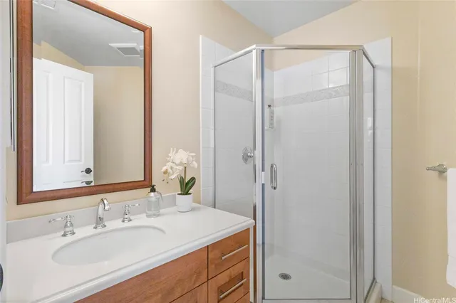 a front view of a building with yellow lighting plants and large tree