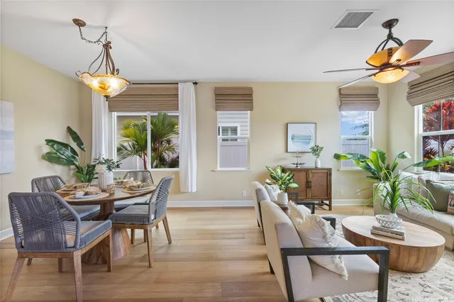 a dining room with furniture potted plants and wooden floor