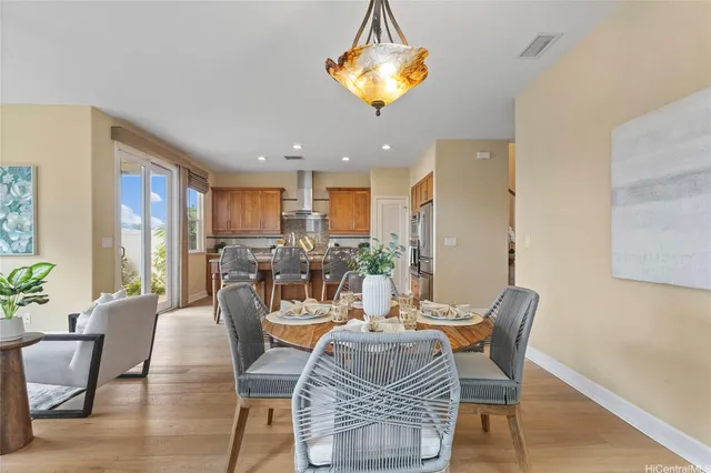 a dining room with furniture a chandelier and wooden floor