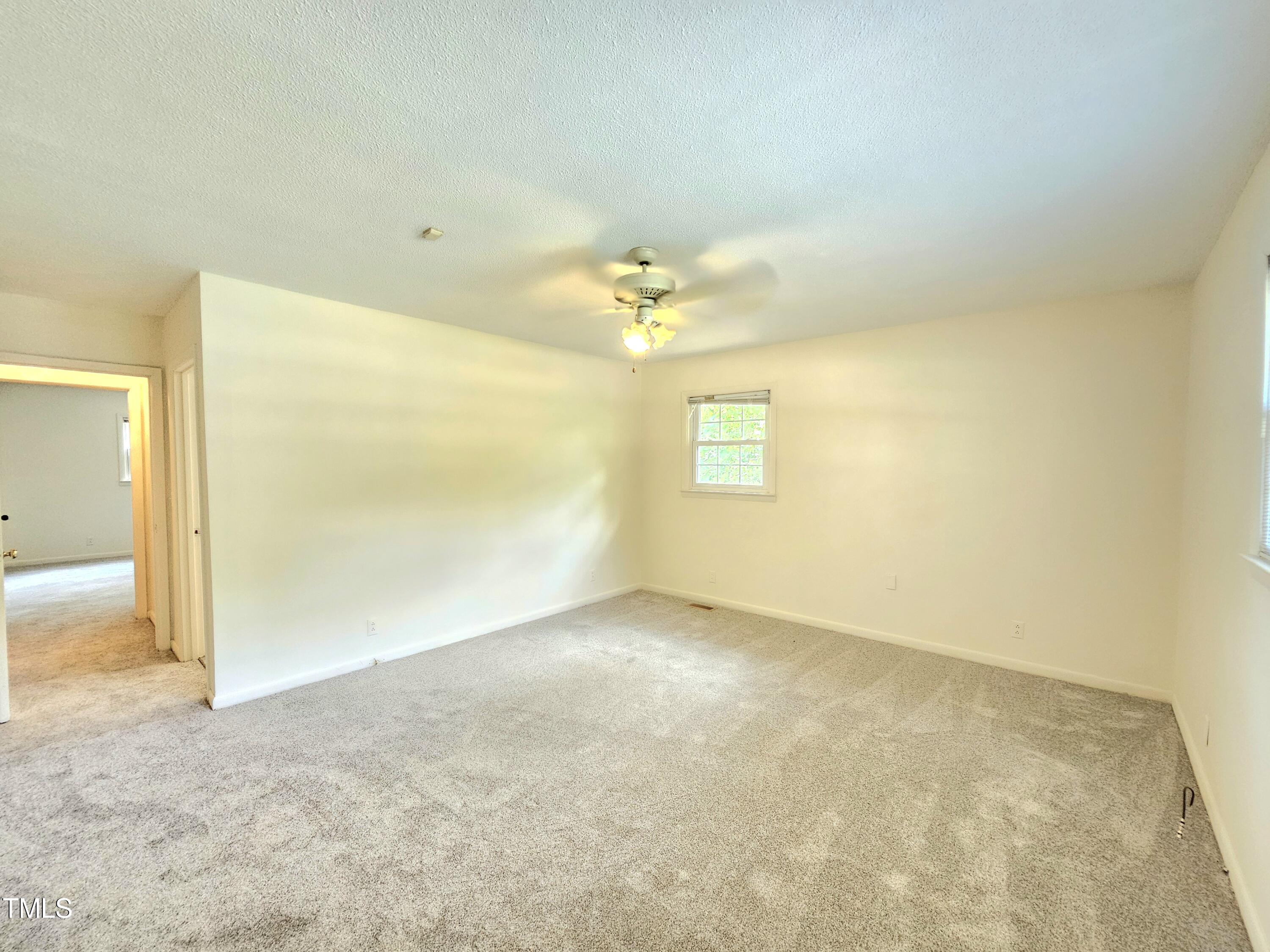 400 Harrill Circle Spring Lake, NC 28390 - Photo 17 of 25 an empty room with a chandelier fan and windows