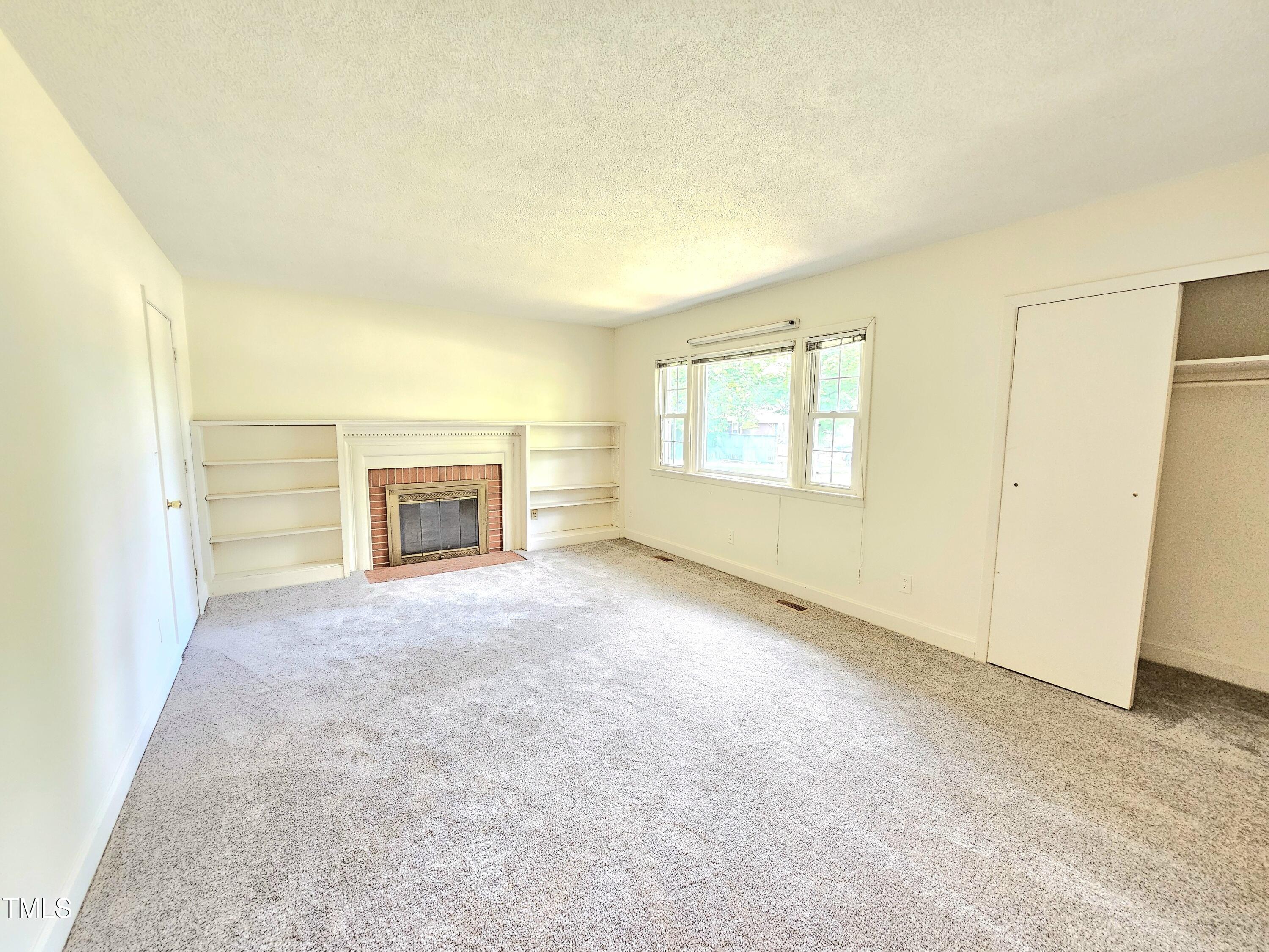400 Harrill Circle Spring Lake, NC 28390 - Photo 9 of 25 an empty room with windows and fireplace
