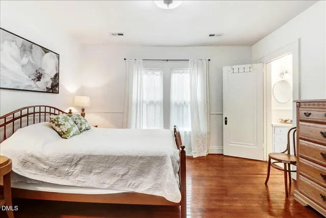 a kitchen with stainless steel appliances white cabinets and wooden floors