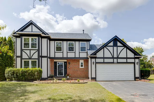 a front view of a house with yard and garage