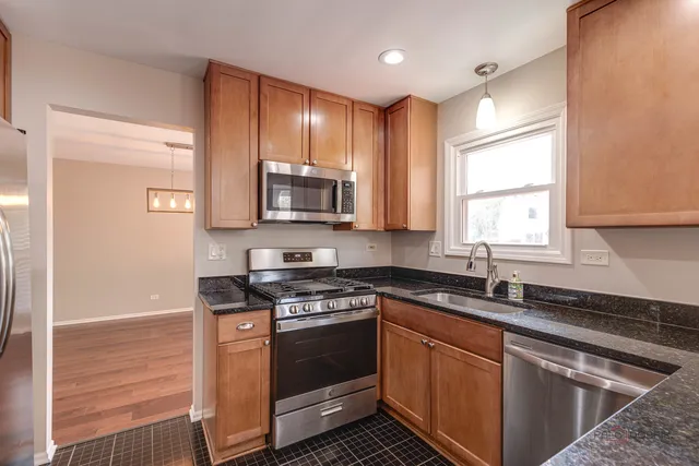 a kitchen with stainless steel appliances granite countertop a sink stove microwave and cabinets