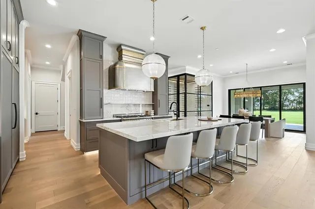 a large kitchen with kitchen island a large counter top space a sink stainless steel appliances and cabinets