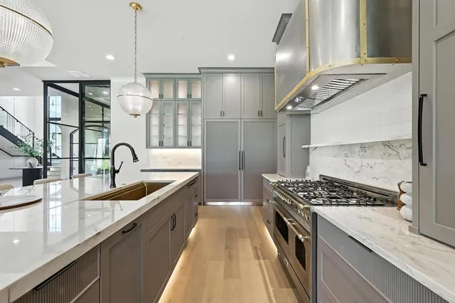 a kitchen with kitchen island stainless steel appliances a sink stove and refrigerator