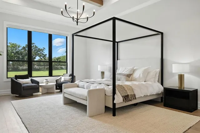 a bedroom with a bed couch and large window