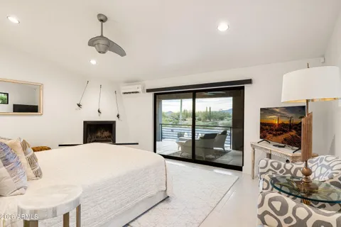 a large white bedroom with furniture and flat tv screen